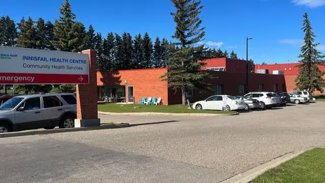 The front of Innisfail Health Centre in Innisfail, Alberta, with its name on the sign in front of the brick building