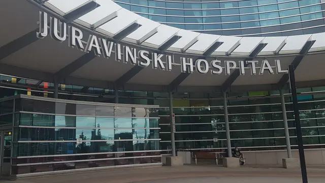 The curved, signed main entrance canopy of Juravinski Hospital in Hamilton, Ontario